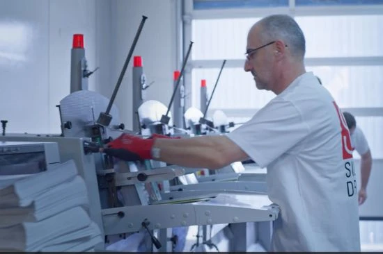 Ein Mitarbeiter von Printnow an den Falzmaschinen